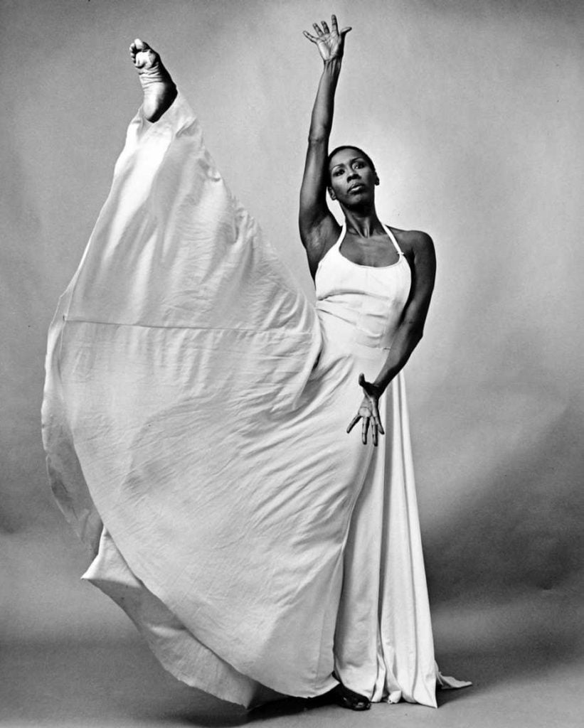 Elegant black and white dance portrait featuring a woman in flowing white gown with expressive pose.