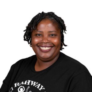 Smiling woman dancing in black T-shirt with AbunDance logo, celebrating dance and wellness.